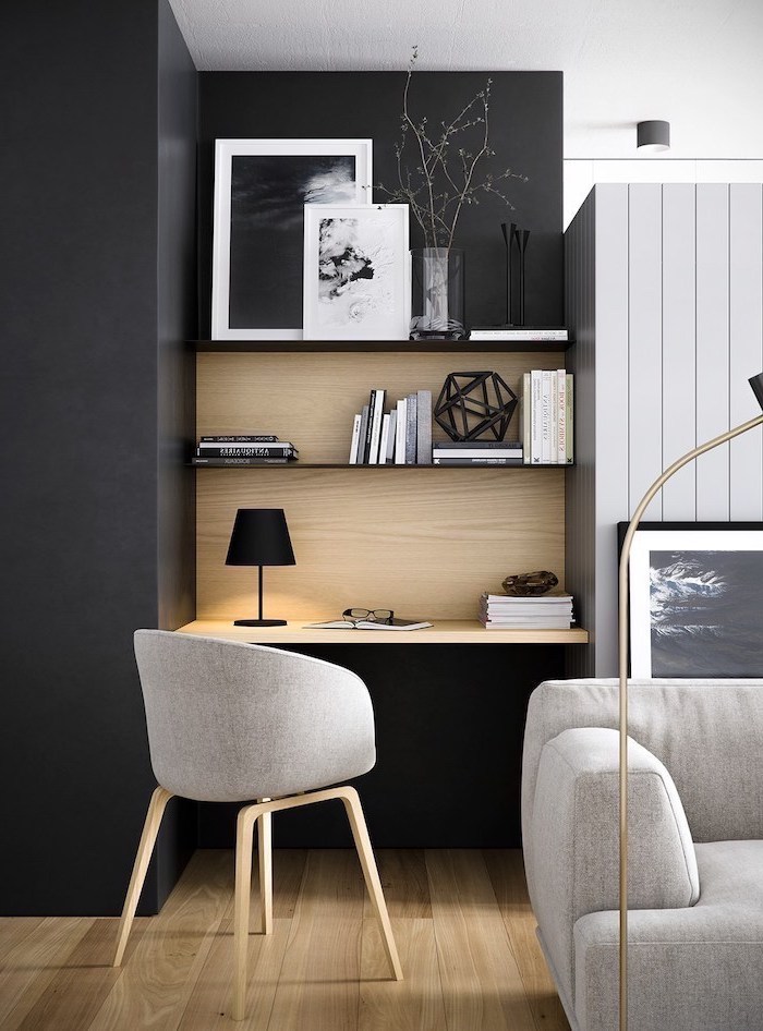 black-wall-wooden-bookshelves-grey-chair-sofa-desk-lamp-home-office-setup-books-paintings